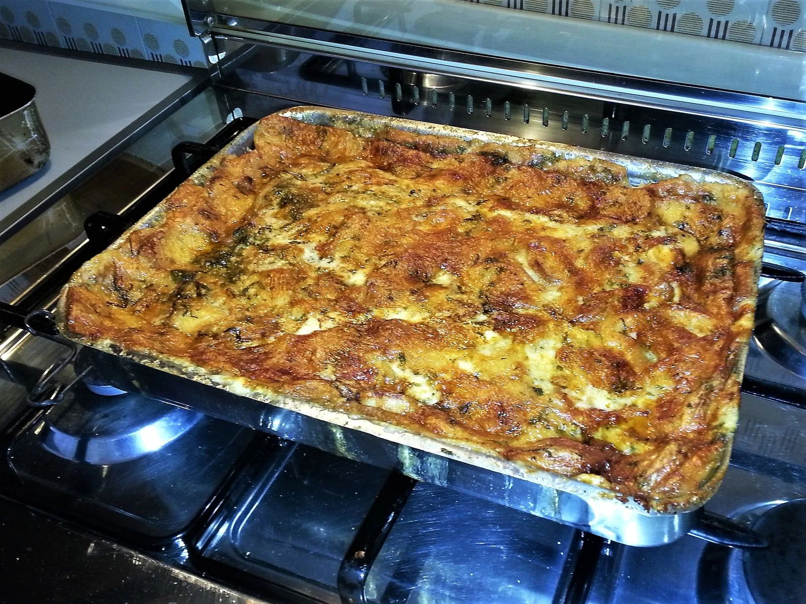 Teglia di suppa cuata, la zuppa gallurese di pane e formaggio, appena sfornata e dorata in superficie